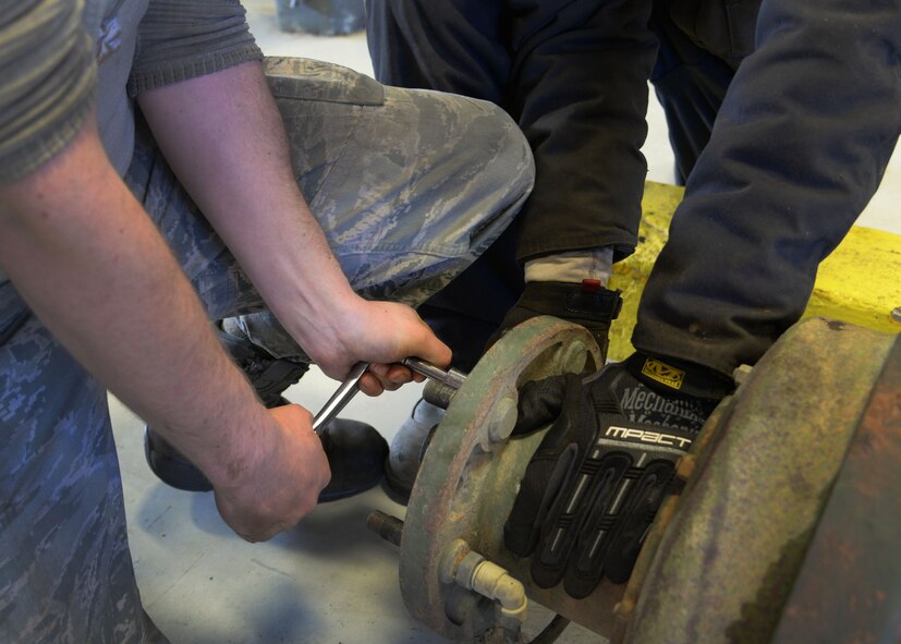 Senior Airman Lloyd Carlyle and Airman 1st Class Joshua Davis, 27th Special Operations Logistics Readiness Squadron fire truck mechanics, work to remove a serviceable axle from a salvaged component for an out-of-service M35 fire truck Feb. 5, 2015 at Cannon Air Force Base, N.M. Utilizing salvaged parts that are readily available cuts wait time that would exist if new parts were ordered and gets vehicles back to units faster. (U.S. Air Force photo/Staff Sgt. Alexxis Mercer)