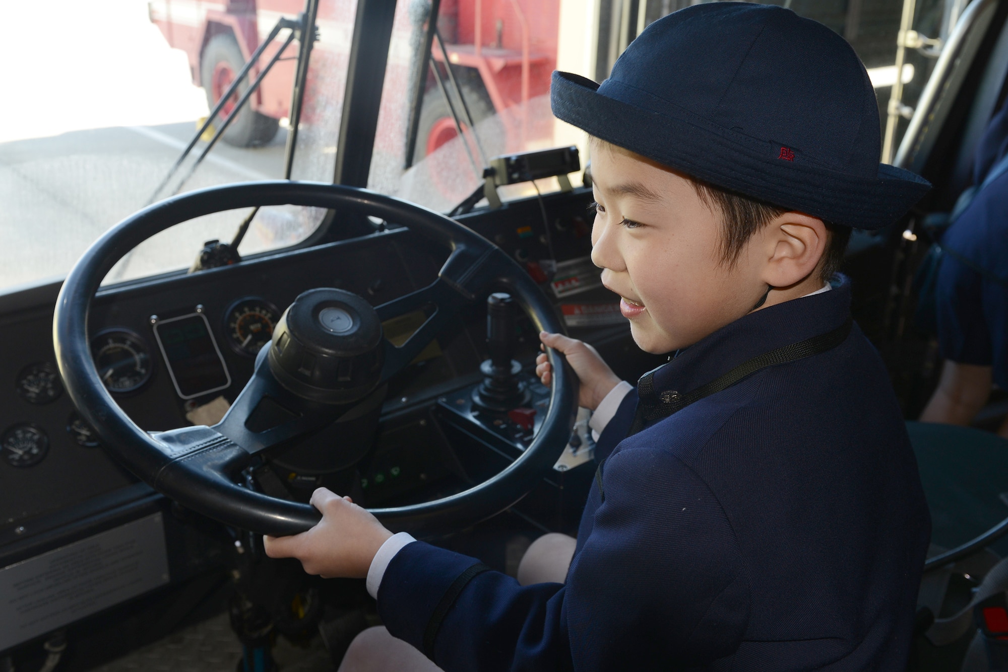 A student from Keimei Gakuen sits inside a fire engine during a tour of 374th Civil Engineer Squadron facilities at Yokota Air Base, Japan, Feb. 3, 2015. The tour was used to strengthen relations with the local community. (U.S. Air Force photo by Airman 1st Class David C. Danford/Released)