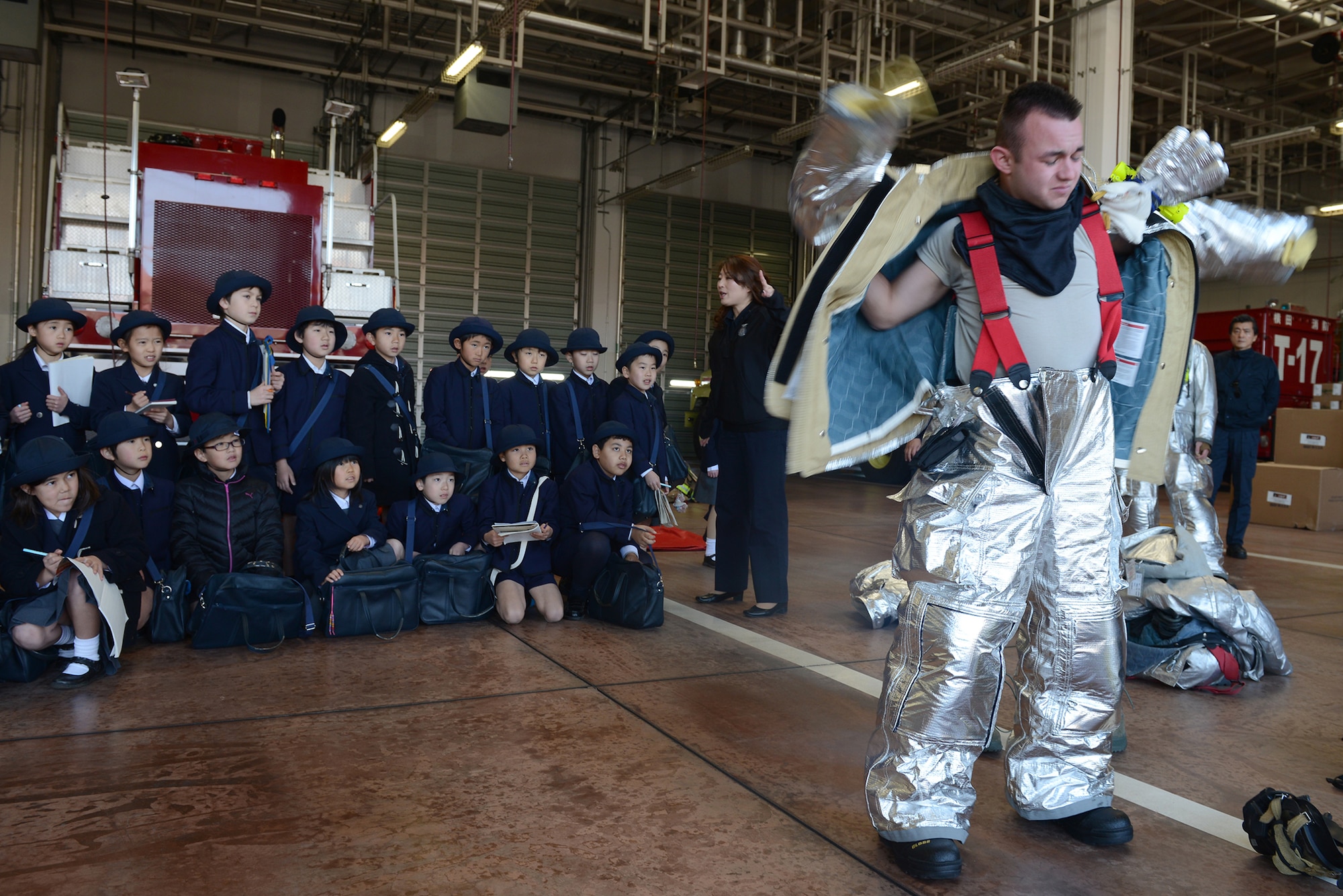 Airman 1st Class Jordan Spiceland, 374th Civil Engineer Squadron firefighter, dons protective gear at Yokota Air Base, Japan, Feb. 3, 2015. Spiceland showcased the fire department’s ability to respond quickly to emergencies as part of a tour for students from Keimei Gakuen. (U.S. Air Force photo by Airman 1st Class David C. Danford/Released)