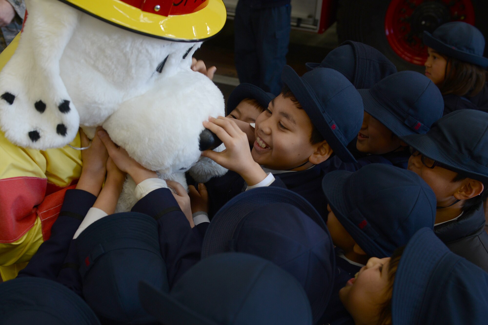Students from Keimei Gakuen play with Sparky the Fire Dog during a tour of 374th Civil Engineer Squadron facilities at Yokota Air Base, Japan, Feb. 3, 2015. The tour was used to strengthen relations with the local community. (U.S. Air Force photo by Airman 1st Class David C. Danford/Released)