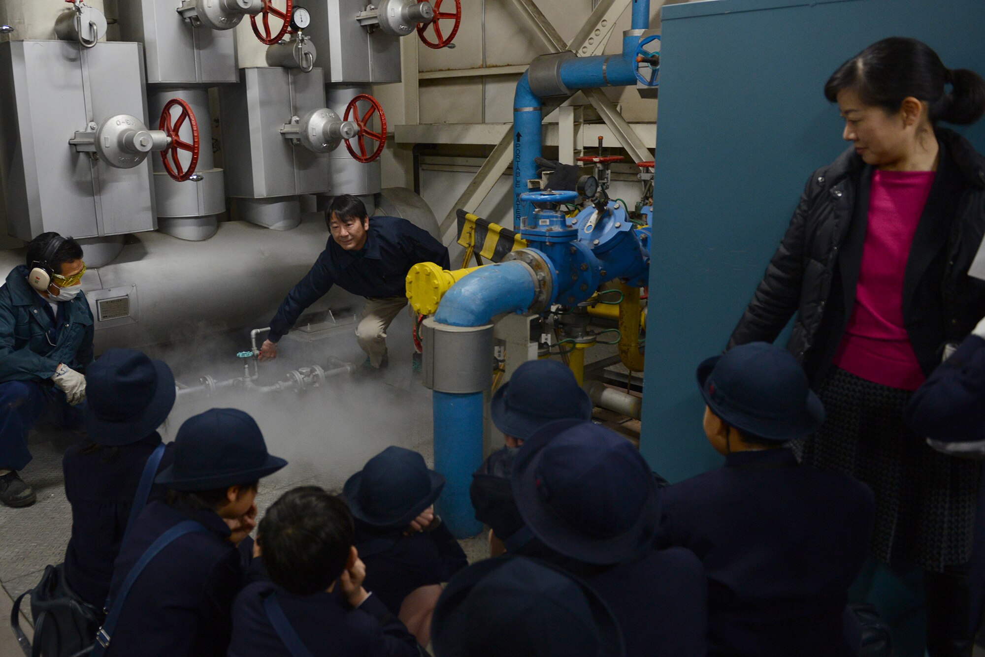 Yoshihiro Takayama, 374th Civil Engineer Squadron boiler plant foreman, turns a valve to release steam during a tour of 374 CES facilities at Yokota Air Base, Japan, Feb. 3, 2015. The tour was used to strengthen relations with the local community. (U.S. Air Force photo by Airman 1st Class David C. Danford/Released)
