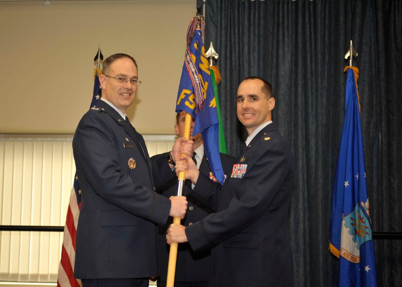 Col. David Stookey, 92nd Mission Support Group commander, passes the guidon to Maj. Daniel Rigsbee as he takes command of the 92nd Force Support Squadron during an assumption of command ceremony Feb. 9, 2015, at Fairchild Air Force Base, Wash. The assumption of command ceremony is a tradition that represents a formal transfer of authority and responsibility. (U.S. Air Force photo/Airman 1st Class Taylor Bourgeous)