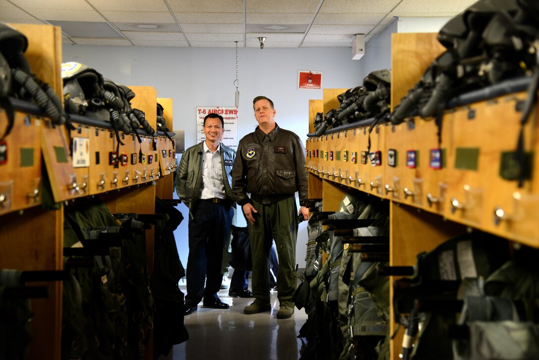 Col. Timothy MacGregor, 47th Operations Group commander, right, gives Col. Benedict Ang, Singapore’s Air Force Training Command commander, a tour of the aircrew flight equipment room on Laughlin Air Force Base, Texas, Feb. 9, 2015. This room is used to store pilot’s oxygen masks, helmets, G-suits and other equipment worn and carried on their flights. (U.S. Air Force photo by Airman 1st Class Ariel D. Delgado)(Released)