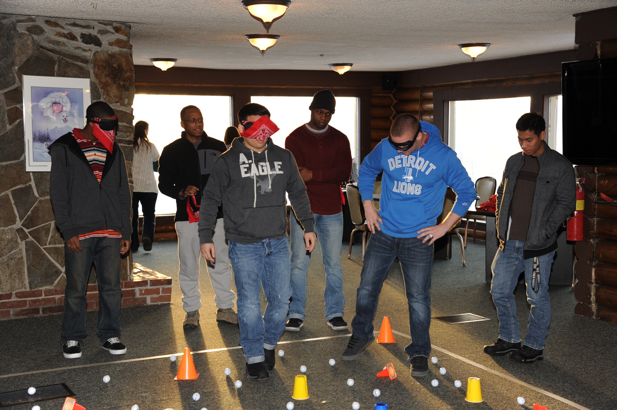 Airmen attempt to guide each other through the golf ball "mine field" during an exercise in communication at a day-long retreat Feb. 6, 2015, Eielson Air Force Base, Alaska. The retreat provided Airmen with interactive discussion, exercises and team building activities to encourage personal and professional growth and development. (U.S. Air Force photo by Staff Sgt. Kirsten Wicker/Released)