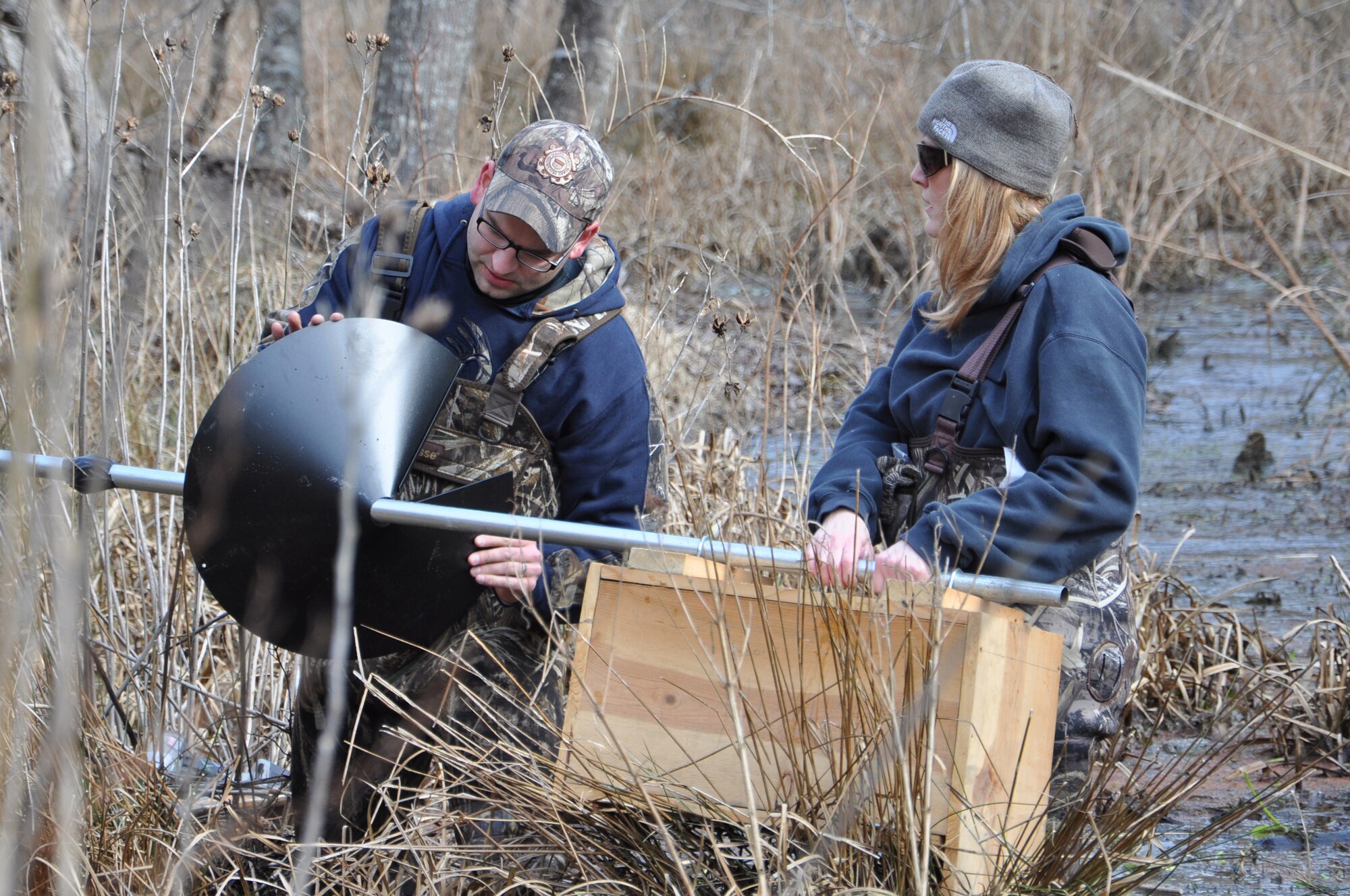 U.S. Coast Guard Chief Petty Officer Kevin Asher, U.S. Coast Guard Training Center Yorktown food service specialist, and his wife, retired U.S. Navy Petty Officer 2nd Class Sharon Asher, install a predator guard for a wood duck nesting box at Fort Eustis, Va., Feb. 7, 2015. The guard is placed under the nesting box to prevent predators from climbing the pole (U.S. Air Force photo by Master Sgt. April Wickes/Released)