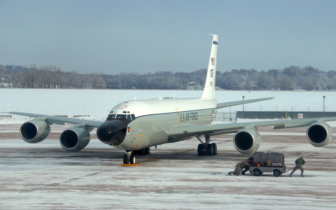 Crew chiefs from the 83rd Aircraft Maintenance Unit, 55 Aircraft Maintenance Squadron move aerospace ground equipment while preparing an RC-135 Rivet Joint for launch Feb. 3 at Offutt Air Force Base Neb. Additional maintenance time is typically needed during winter operations to heat aircraft and to remove snow and ice from the aircraft prior to take-off.  (U.S. Air Force photo by Delanie Stafford/Released)