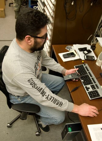Gary Gautieri, base land mobile radio manager, programs new radios and adds them into a database at the land mobile radio shop on Nellis Air Force Base, Nev., Jan. 16, 2015. Gautieri was programming radios in preparation for Red Flag 15-1. (U.S. Air Force photo by Airman 1st Class Mikaley Towle)