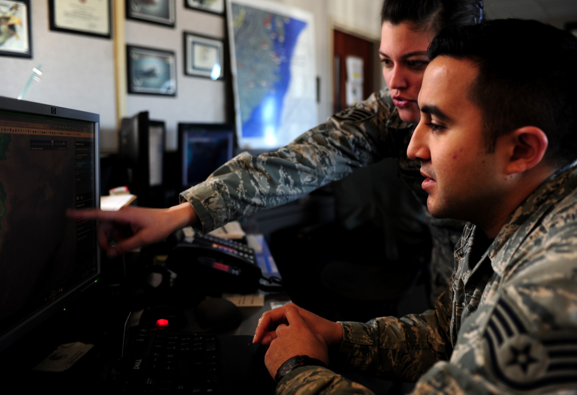 From left, U.S. Air Force Staff Sgt. Elizabeth Darnall, 1st Operations Support Squadron weather craftsman, and Staff Sgt. Adman Ybarra, 1st OSS weather forecaster, analyze surface observations ahead of an oncoming low pressure system at Langley Air Force  Base, Va., Feb. 6, 2015. Weather personnel prepare forecasts, issue weather warnings and brief pilots to ensure flight safety and awareness. (U.S. Air Force photo by Airman 1st Class Areca T. Wilson/Released)