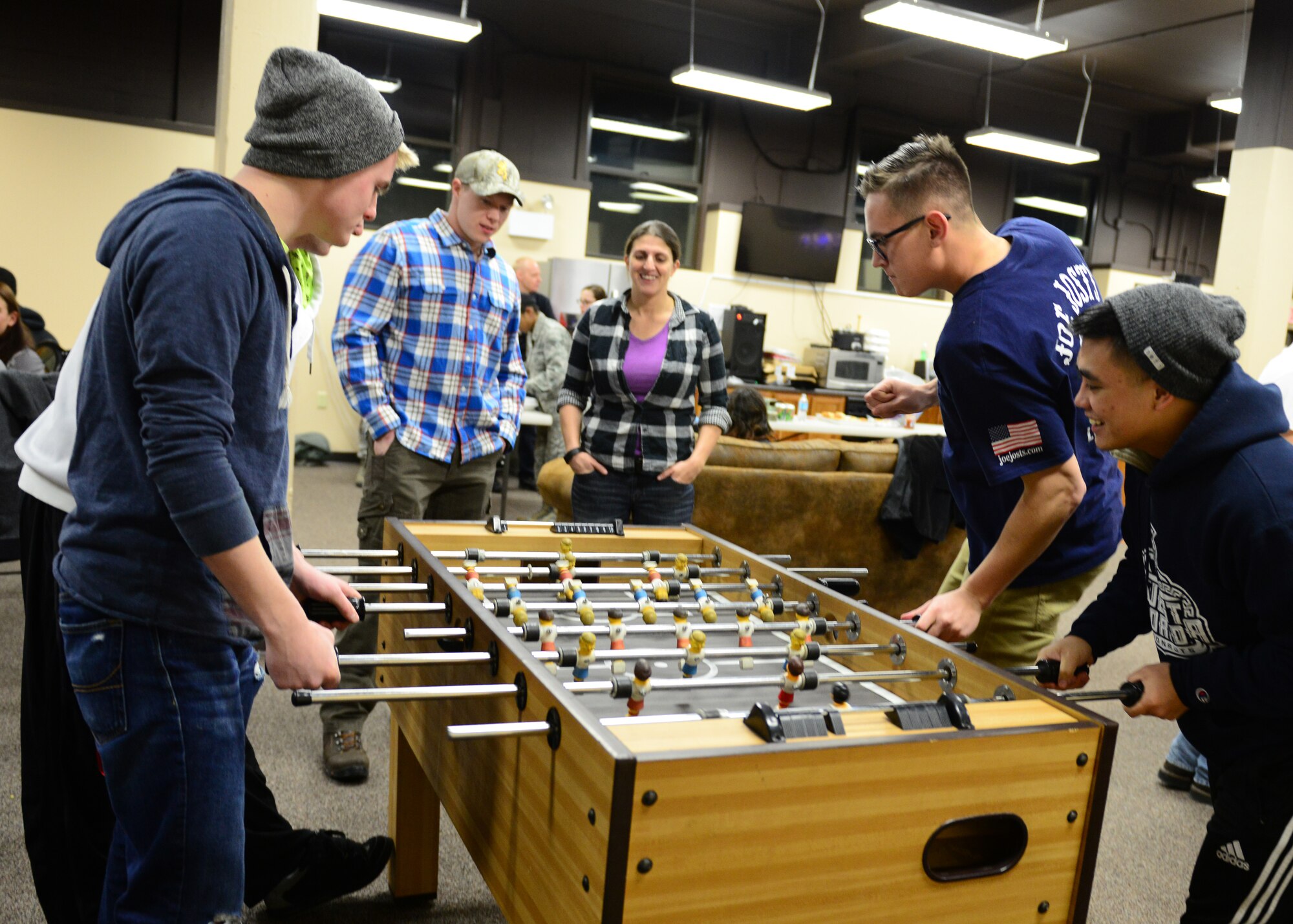 Airmen play a game on the foos ball table at the Icebox in building 2266 during an Airman's Dinner at Eielson Air Force Base, Alaska, Jan. 20, 2015. (U.S. Air Force photo by Senior Airman Ashley Nicole Taylor/Released)