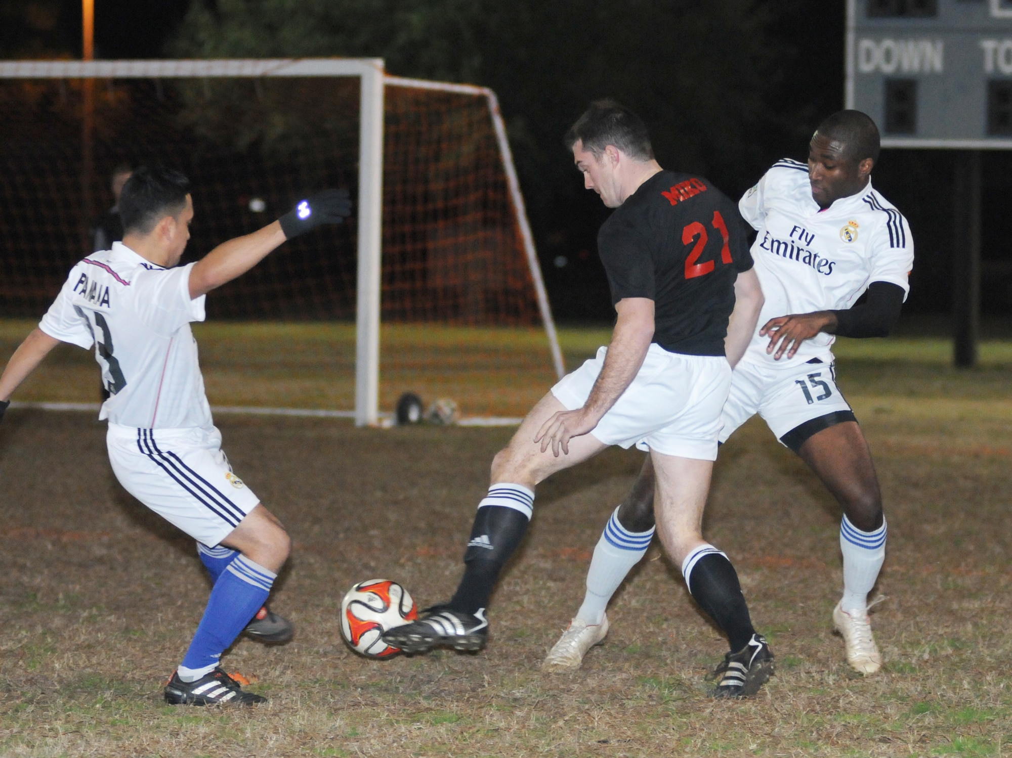 Erik Schweiss, 333rd Training Squadron A team, (center), dribbles the ball between Jorge Panama and Emmanuel Freduah-Agyemang, 81st Surgical Operations Squadron, during the intramural soccer conference championship game Feb. 5, 2015, at Keesler Air Force Base, Miss. The 81st MSGS defeated 333rd TRSA team, 3-2. The 81st MSGS was the La Liga League champion while the 333rd TRS A team was the Premier League champion. (U.S. Air Force photo by Kemberly Groue)