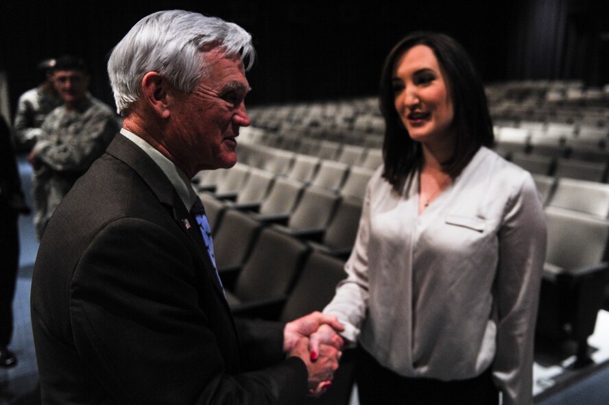 Retired Lt. Col. Barry Bridger, a Vietnam veteran, prisoner of war, and former member of Seymour Johnson Air Force Base, North Carolina, shakes hands with Emily Tucker, Miss Goldsboro 2014, during the 4th Fighter Wing’s Leadership Lecture Series, Feb. 4, 2014, at Seymour Johnson AFB. Bridger spoke with Airmen about the trials he faced during his imprisonment at the Hanoi Hilton prison camp and how he overcame torture and mistreatment by committing to his values. (U.S. Air Force photo/Airman 1st Class Brittain Crolley)