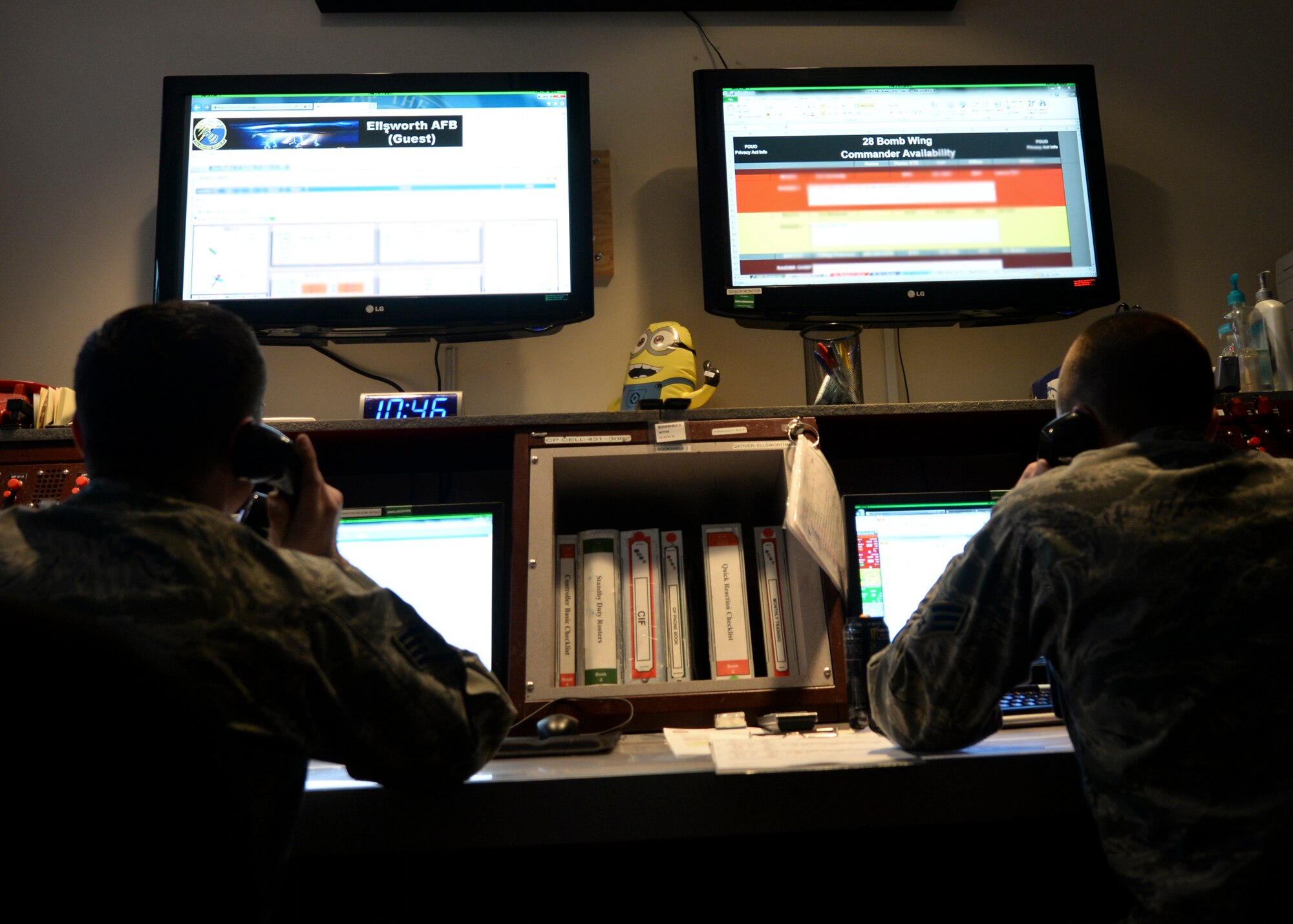 Staff Sgt. Jesus Ortiz and Senior Airman Kyle Patru, 28th Bomb Wing command post emergency actions controllers, answer calls at the emergency actions console inside the command post at Ellsworth Air Force Base, S.D., Jan. 27, 2015. Command post personnel work closely with the bomb wing commander to help facilitate the base mission. (U.S. Air Force photo by Senior Airman Anania Tekurio/Released)