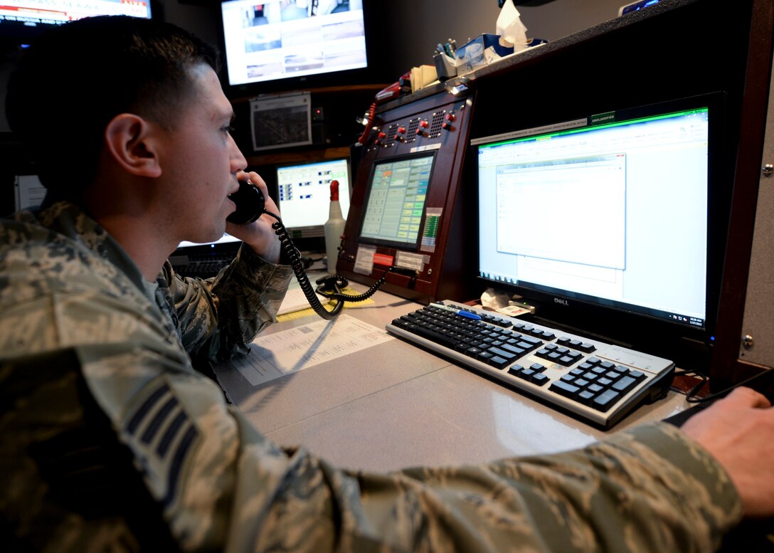 Staff Sgt. Jesus Ortiz, 28th Bomb Wing command post emergency actions controller, receives mission information at the emergency actions console inside the command post at Ellsworth Air Force Base, S.D., Jan. 27, 2015. Command post personnel are responsible for maintaining constant knowledge of flight operations being conducted on base. (U.S. Air Force photo by Senior Airman Anania Tekurio/Released)