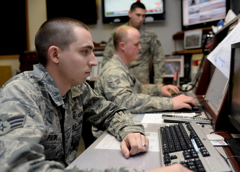 Senior Airman Kyle Patru, 28th Bomb Wing command post senior emergency actions controller, disseminates messages and information throughout the base from inside the command post at Ellsworth Air Force Base, S.D., Jan. 27, 2015. Command post controllers ensure base operations run smoothly and effectively by alerting, directing and reporting information 24/7, 365 days a year. (U.S. Air Force photo by Senior Airman Anania Tekurio/Released)