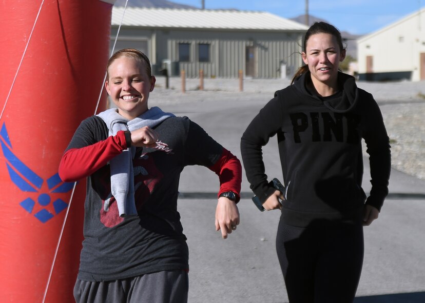 Senior Airmen Stephanie Rocha, left, 99th Ground Combat Training Squadron combat arms training and maintenance instructor, and Grace Biro, right, 99th GCTS supply technician, smile as they finish a 5K run Feb. 4, 2014 at silver flag training range. The 99th Ground Combat Training Squadron received the first Air Combat Command Security Forces Order of the Shield unit award during a ceremony Feb. 6, 2015, at Creech Air Force Base, Nevada for its contributions to the security forces career field. (U.S. Air Force Photo/Tech. Sgt. Shad Eidson/Released)

