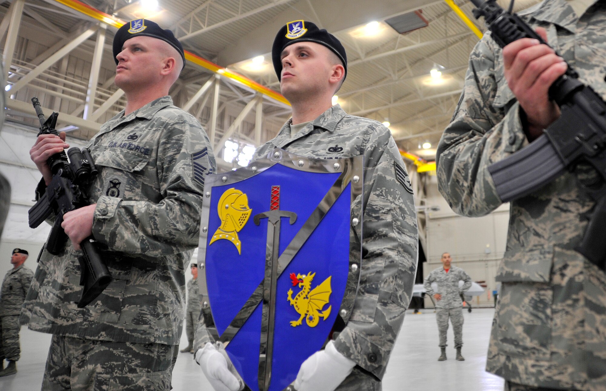 The Order of the Shield Detail waits to present the 99th Ground Combat Training Squadron commander with the honorary shield during an Air Combat Command Security Forces Order of the Shield ceremony Feb. 6, 2015, at Creech Air Force Base, Nevada. The shield represents defenders as the true shield of protection against attacks, and recognizes them for their contributions to security forces within ACC. (U.S. Air Force photo by Airman 1st Class Christian Clausen/Released)
