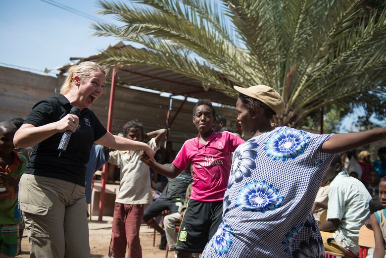 DJIBOUTI -- Staff Sgt. Jill Diem, U.S. Air Forces in Europe Band vocalist, dances with children during a performance at the Caritas Center in Djibouti Feb. 8, 2015. The USAFE Band, rock ensemble Touch n’ Go, performed outreach concerts in the local community while traveling with African Partnership Flight-Djibouti. (U.S. Air Force photo/Tech. Sgt. Benjamin Wilson) 