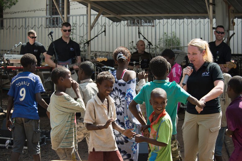 DJIBOUTI -- Staff Sgt. Jill Diem, U.S. Air Forces in Europe Band vocalist, dances with children during a performance at the Caritas Center in Djibouti Feb. 8, 2015. The USAFE Band, rock ensemble Touch n’ Go, performed outreach concerts in the local community while traveling with African Partnership Flight-Djibouti. (U.S. Air Force photo/Tech. Sgt. Benjamin Wilson) 