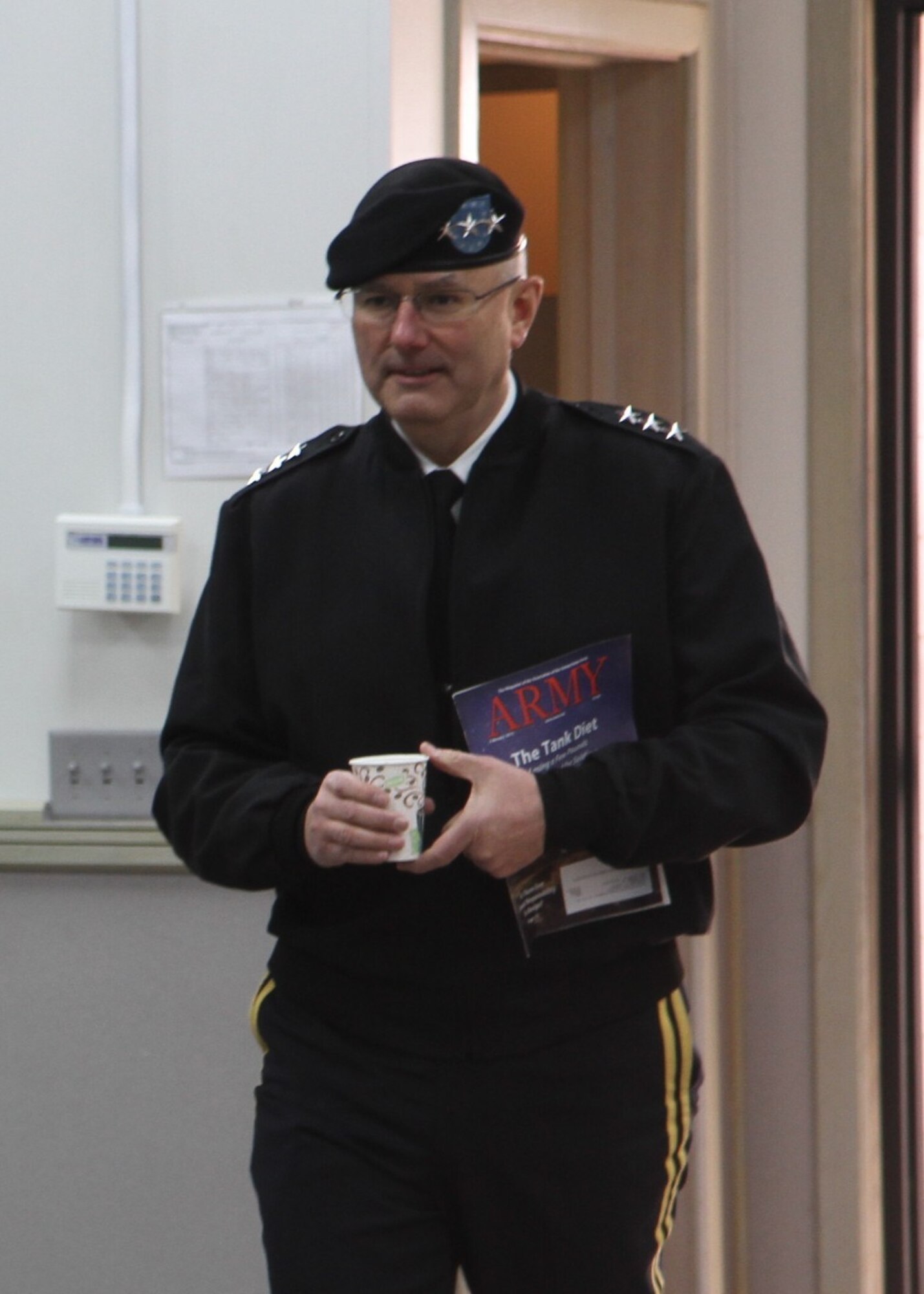 Lt. Gen. Michael Tucker prepares to address the 188th Infantry Brigade during a town hall. He carries the Army magazine, featuring an article about Operation Bold Shift. (U.S. Army photo by Sgt. 1st Class Stephanie Widemon/Released)