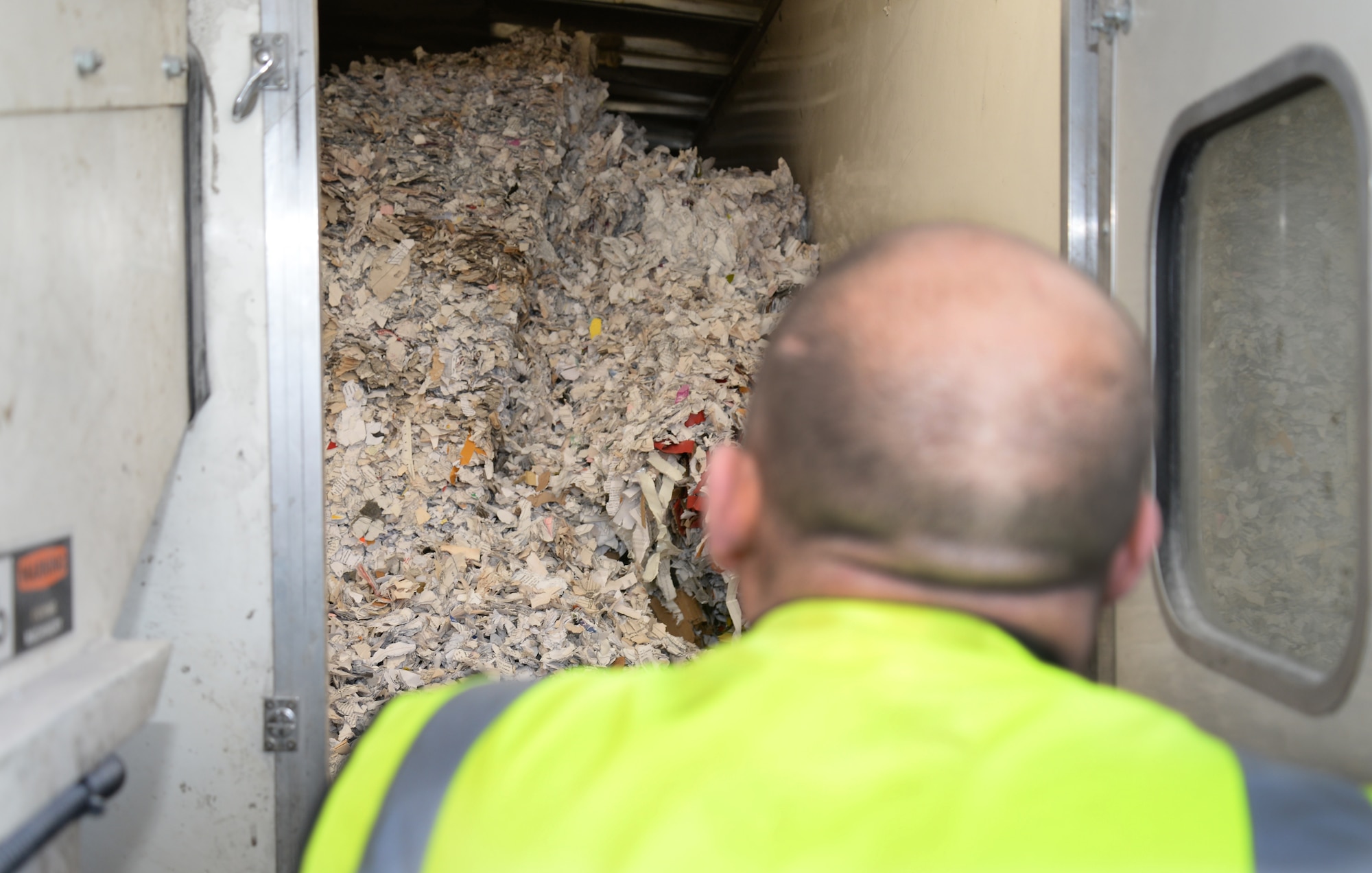 Scott Taylor, Shred Station contractor from Harlow, Essex, inspects paper after it has been shredded Feb. 6, 2015, on RAF Mildenhall, England. The mobile shred station was available to base personnel to shred non-classified documents containing personal identification information. (U.S. Air Force photo by Airman 1st Class Jonathan Light/Released)