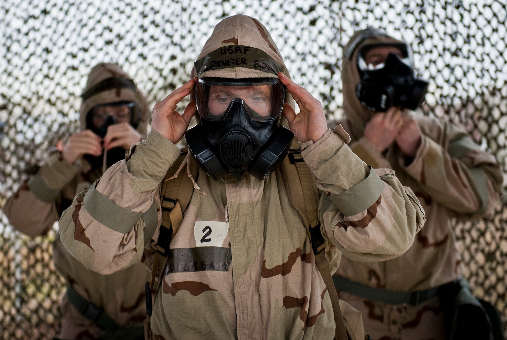 Staff Sgt. Ebenezer Evanoff, of the 96th Civil Engineer Squadron, adjusts his hood and gas mask during a rainy Phase II readiness exercise Feb. 4 at Eglin Air Force Base, Fla.  A Phase II evaluates an Airman’s ability to meet wartime and contingency taskings of employing and sustaining the force and the ability to survive and operate. More than 30 potential deployers received classroom and practical field training during the exercise. (U.S. Air Force photo/Ilka Cole)