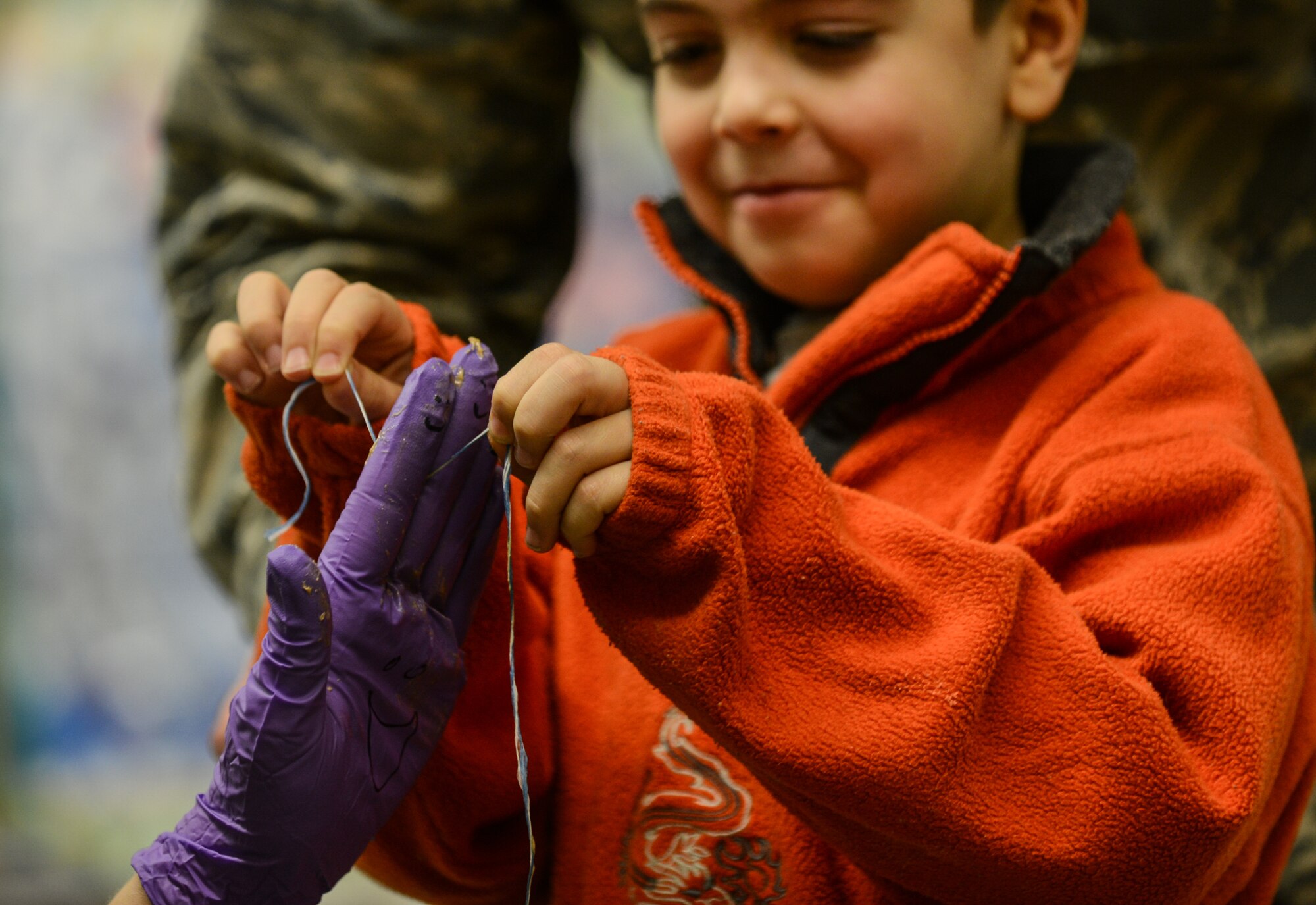 A student runs floss through the fingers of Maj. Audra Myers, 86th Dental Squadron dentist, as an example of correct flossing techniques Ramstein Air Base, Germany, Feb.  6, 2014. The 86th Dental Squadron visits Ramstein Elementary School annually during Children’s Dental Health Month. (U.S. Air Force photo/Senior Airman Nicole Sikorski)