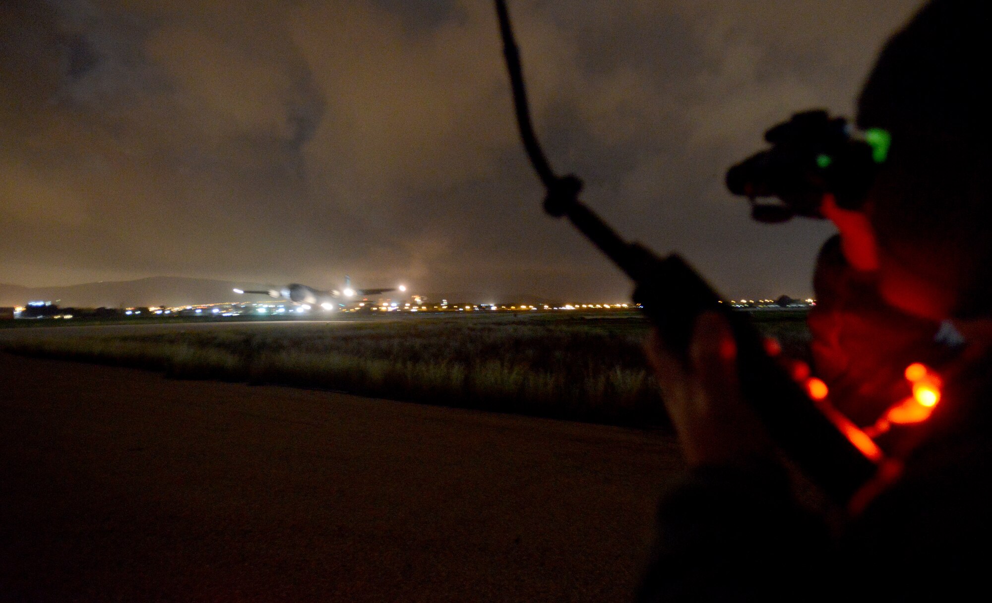 Tech. Sgt. George Broom, 435th Air Mobility Squadron contingency airfield manager, looks through night vision goggles to monitor the air space as a C-130J Super Hercules takes off of a runway in Elefsis, Greece, Feb. 5, 2015. The 435th Air Ground Operations Wing's Contingency Response Group is implementing a new landing zone program that will allow members of CRGs prepare landing zone operations from picking the location to actually providing limited air traffic control. (U.S. Air Force photo/Senior Airman Timothy Moore)