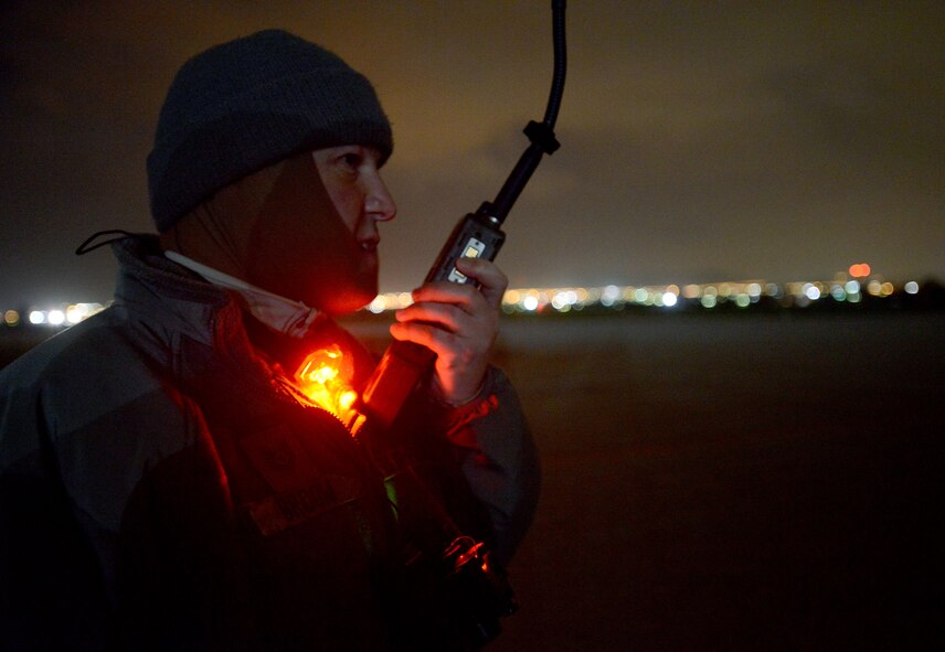 Tech. Sgt. George Broom, 435th Air Mobility Squadron contingency airfield manager, speaks to the crew of a C-130J Super Hercules as it approaches a runway in Elefsis, Greece, Feb. 5, 2015. The 435th Air Ground Operations Wing's Contingency Response Group is implementing a new landing zone program that will allow members of CRGs prepare landing zone operations from picking the location to actually providing limited air traffic control. (U.S. Air Force photo/Senior Airman Timothy Moore)