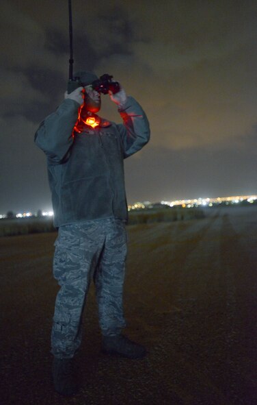 Tech. Sgt. George Broom, 435th Air Mobility Squadron contingency airfield manager, looks through night vision goggles to monitor a C-130J Super Hercules's approach of a runway in Elefsis, Greece, Feb. 5, 2015. The 435th Air Ground Operations Wing's Contingency Response Group is implementing a new landing zone program that will allow members of CRGs prepare landing zone operations from picking the location to actually providing limited air traffic control. (U.S. Air Force photo/Senior Airman Timothy Moore)