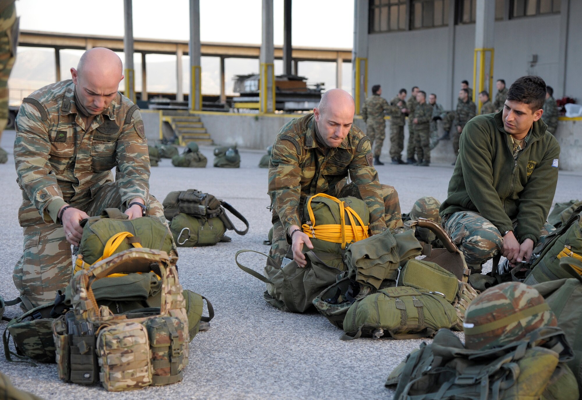 Hellenic Air Force paratroopers inspect their parachutes before boarding a U.S. Air Force C-130J Super Hercules for a night jump during the Stolen Cerberus II flying training deployment in Elefsis, Greece, Feb. 4, 2015. The FTD is designed to improve the interoperability of the U.S. and Greek Air Forces. It is being held from Feb. 2 to 14. (U.S. Air Force photo/Senior Airman Timothy Moore)