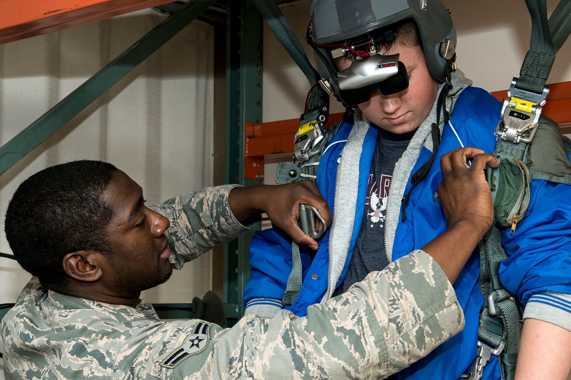U.S. Air Force Airman First Class Ernest St. Amand, 2nd Operations Support Squadron aircrew flight equipment technician, straps a Greenacres Middle School student into the virtual parachute trainer during a tour on Jan. 30, 2015, Barksdale Air Force Base, La. The student, who wants to be an Air Force pilot, participated in a "Shadow Day" and was sponsored by the Air Force Reserve Command's 307th Bomb Wing to experience a day in the life of a B-52 pilot. (U.S. Air Force photo by Master Sgt. Greg Steele/Released)