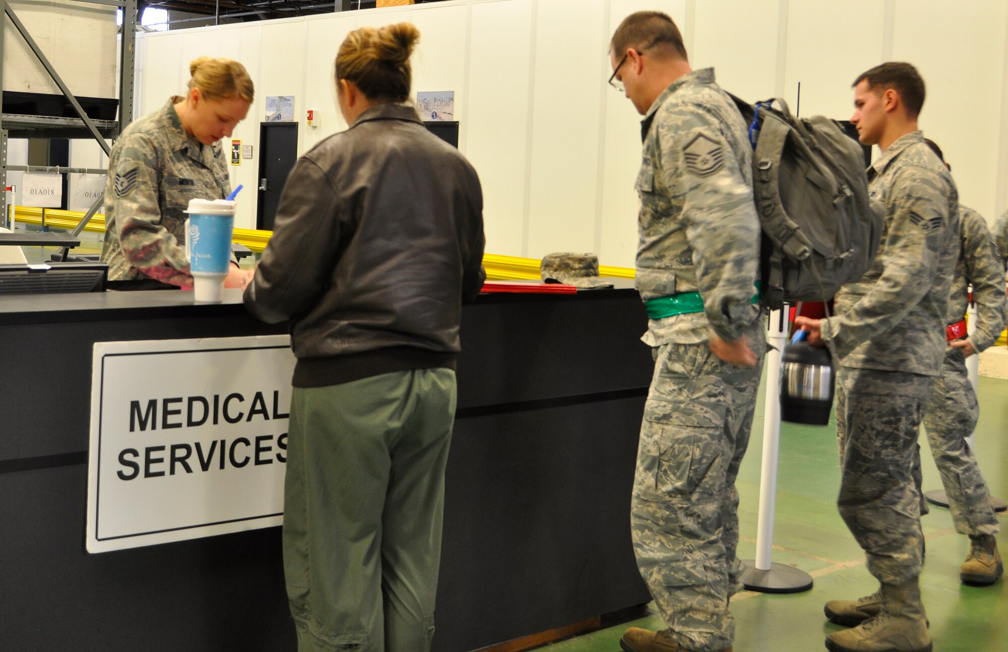 Tech. Sgt. Megan Morse (left), 446th Aerospace Medicine Squadron medical technician and NCO in charge of immunizations, reviews medical deployment folders as Reservists progress through a deployment processing line at the logistics readiness warehouse Feb. 7, 2015. (U.S. Air Force Reserve photo by Master Sgt. Minnette Mason)