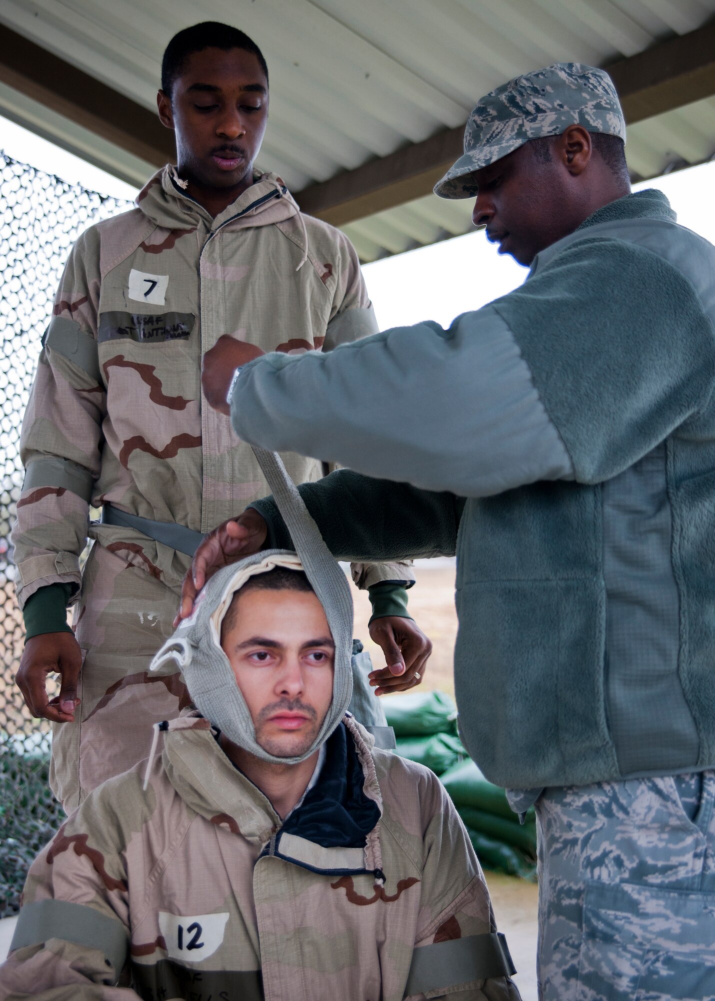 An exercise evaluator removes a bandage from a simulated victims head after the Airmen performed a self-aid and buddy care demonstration during a rainy Phase II readiness exercise Feb. 4 at Eglin Air Force Base, Fla.  A Phase II evaluates an Airman’s ability to meet wartime and contingency taskings of employing and sustaining the force and the ability to survive and operate. More than 30 potential deployers received classroom and practical field training during the exercise. (U.S. Air Force photo/Samuel King Jr.)