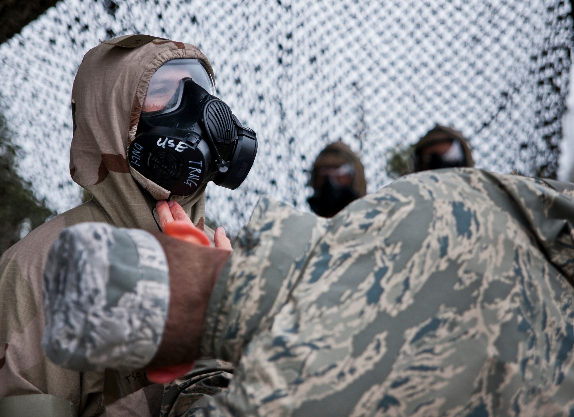 A 96th Civil Engineer Squadron readiness Airman checks a deployer’s mission oriented protective posture gear to ensure it is properly sealed during a rainy Phase II readiness exercise Feb. 4 at Eglin Air Force Base, Fla.  A Phase II evaluates an Airman’s ability to meet wartime and contingency taskings of employing and sustaining the force and the ability to survive and operate. More than 30 potential deployers received classroom and practical field training during the exercise. (U.S. Air Force photo/Samuel King Jr.)