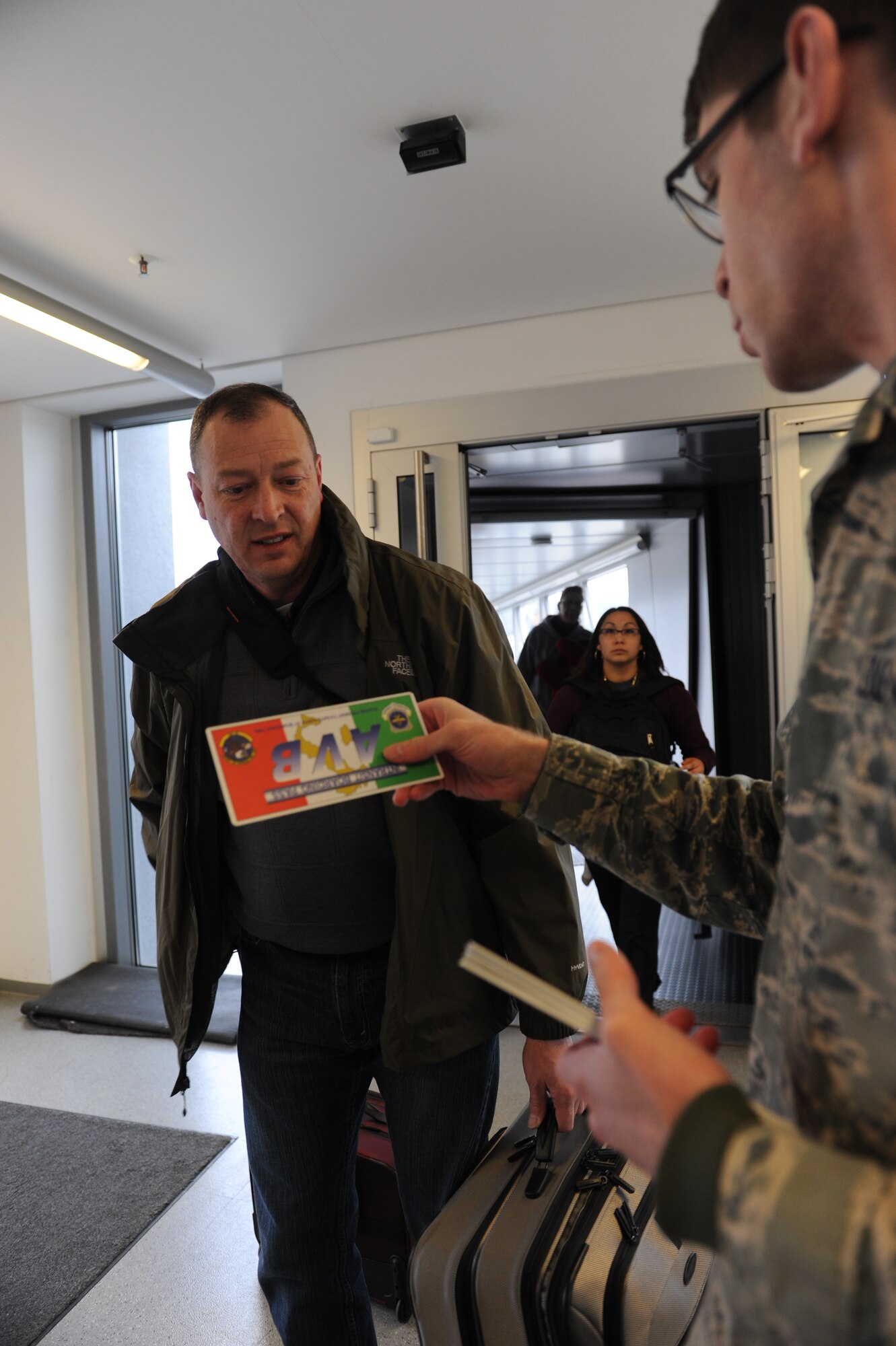 Airman 1st Class Ben Fisher, 721st Aerial Port Squadron passenger service agent, hands a boarding pass to a passenger on Ramstein Air Base, Germany, Feb. 4, 2015. The terminal transports service members who are permanently changing duty stations and those who are eligible to travel using space available. (U.S. Air Force Photo/Airman 1st Class Michael Stuart) 