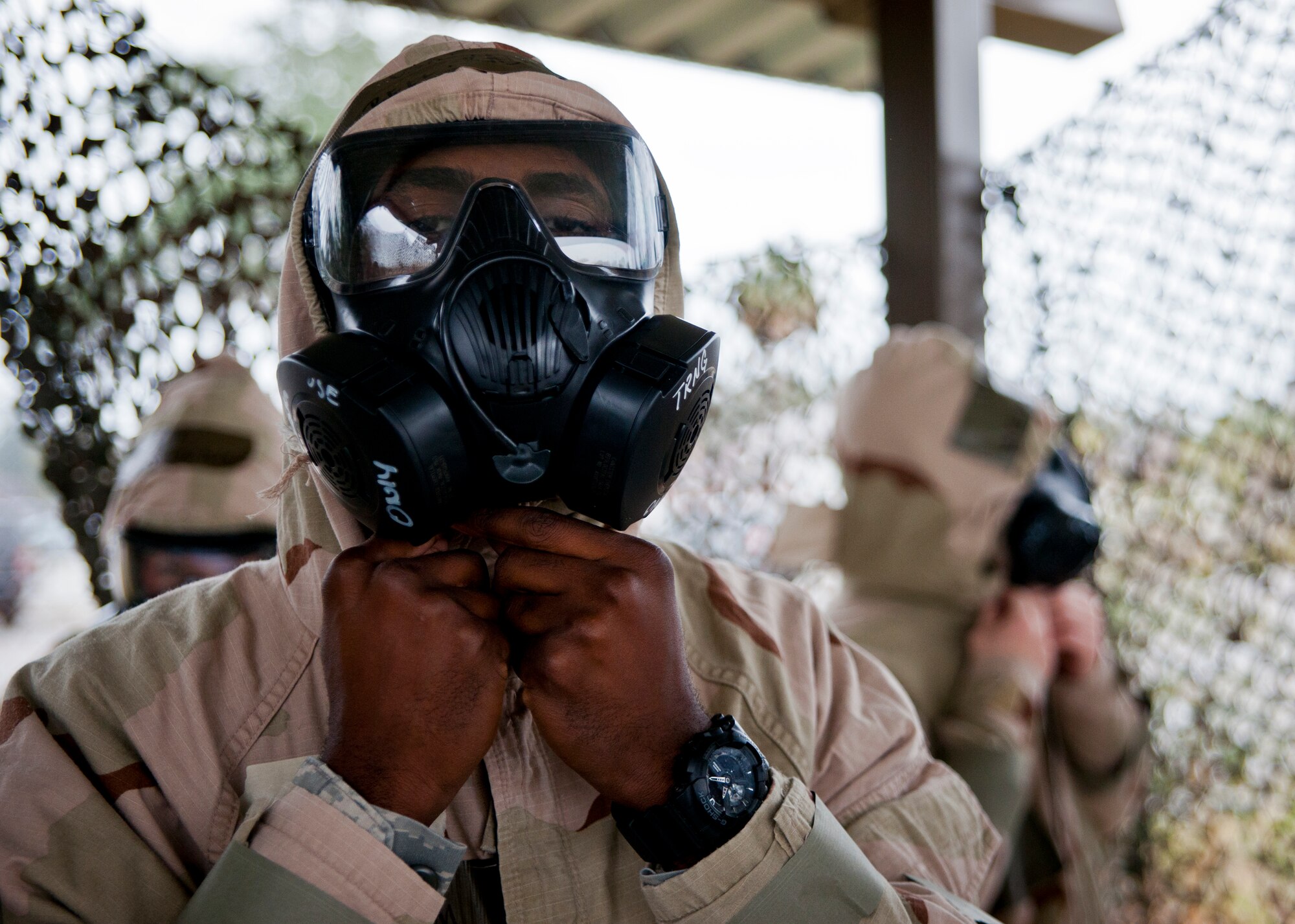 An Airman protects his neck by ensuring his suit is properly sealed during a rainy Phase II readiness exercise Feb. 4 at Eglin Air Force Base, Fla.  A Phase II evaluates an Airman’s ability to meet wartime and contingency taskings of employing and sustaining the force and the ability to survive and operate. More than 30 potential deployers received classroom and practical field training during the exercise. (U.S. Air Force photo/Samuel King Jr.)