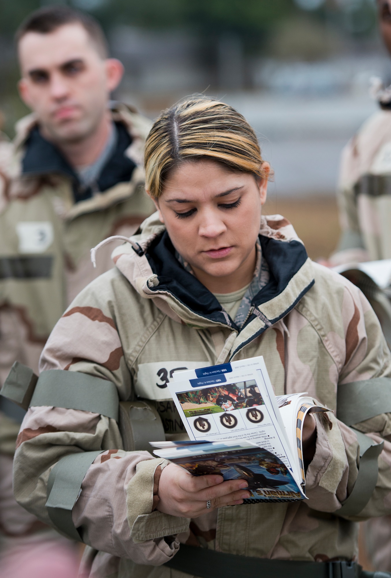 An Airman reviews her training manual during a Phase II readiness exercise Feb. 4 at Eglin Air Force Base, Fla.  A Phase II evaluates an Airman’s ability to meet wartime and contingency taskings of employing and sustaining the force and the ability to survive and operate. More than 30 potential deployers received classroom and practical field training during the exercise. (U.S. Air Force photo/Samuel King Jr.)