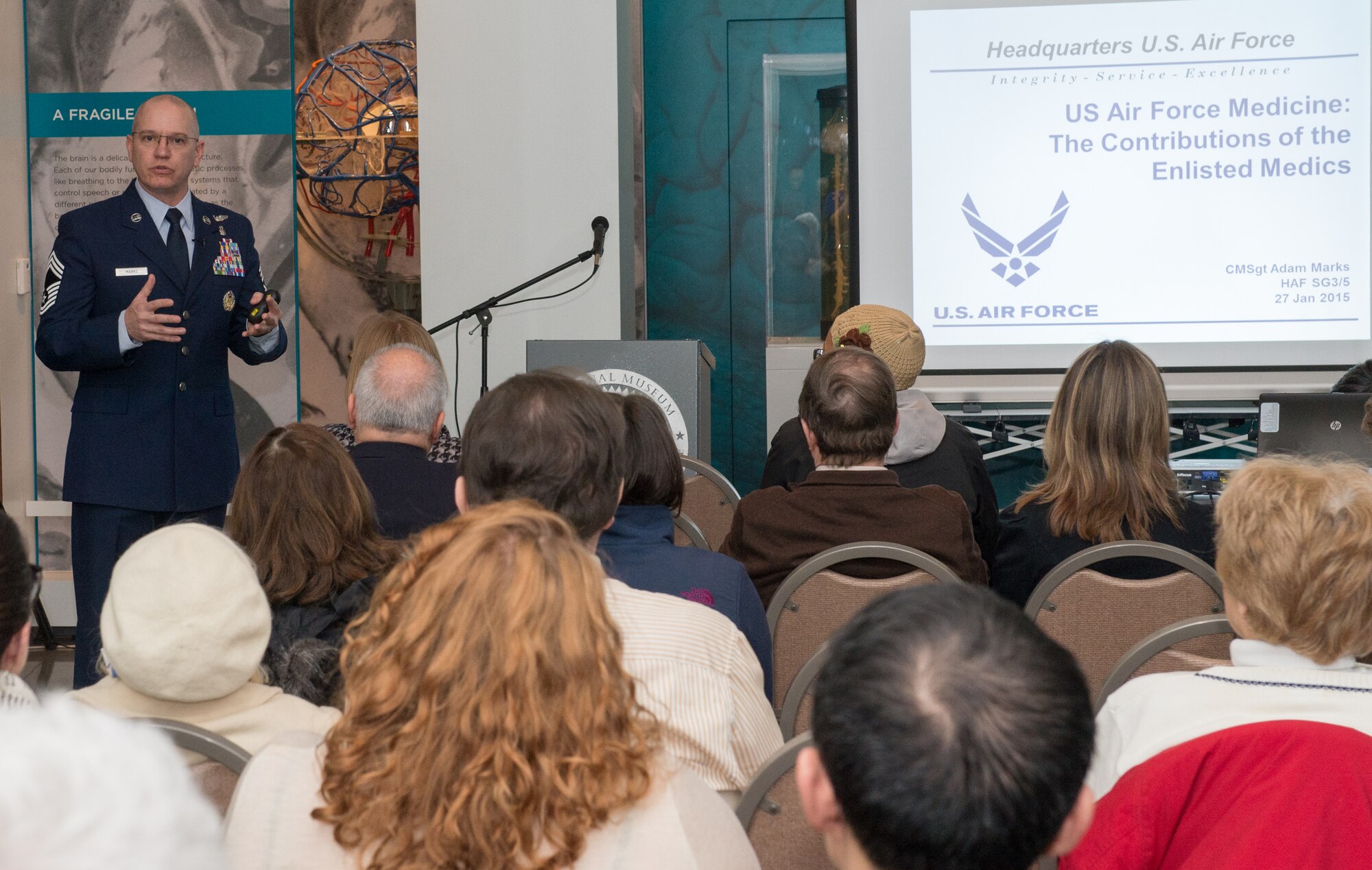 Chief Master Sgt. Adam H. Marks, Chief, Medical Operations and Research, Office of the U.S. Air Force Surgeon General, discusses the training involved with becoming an Air Force medic during a presentation at the National Museum of Health and Medicine’s monthly Medical Museum Science Café January 27, 2015. (Disclosure: This image has been cropped to emphasize the subject.) (National Museum of Health and Medicine photo by Matthew Breitbart)