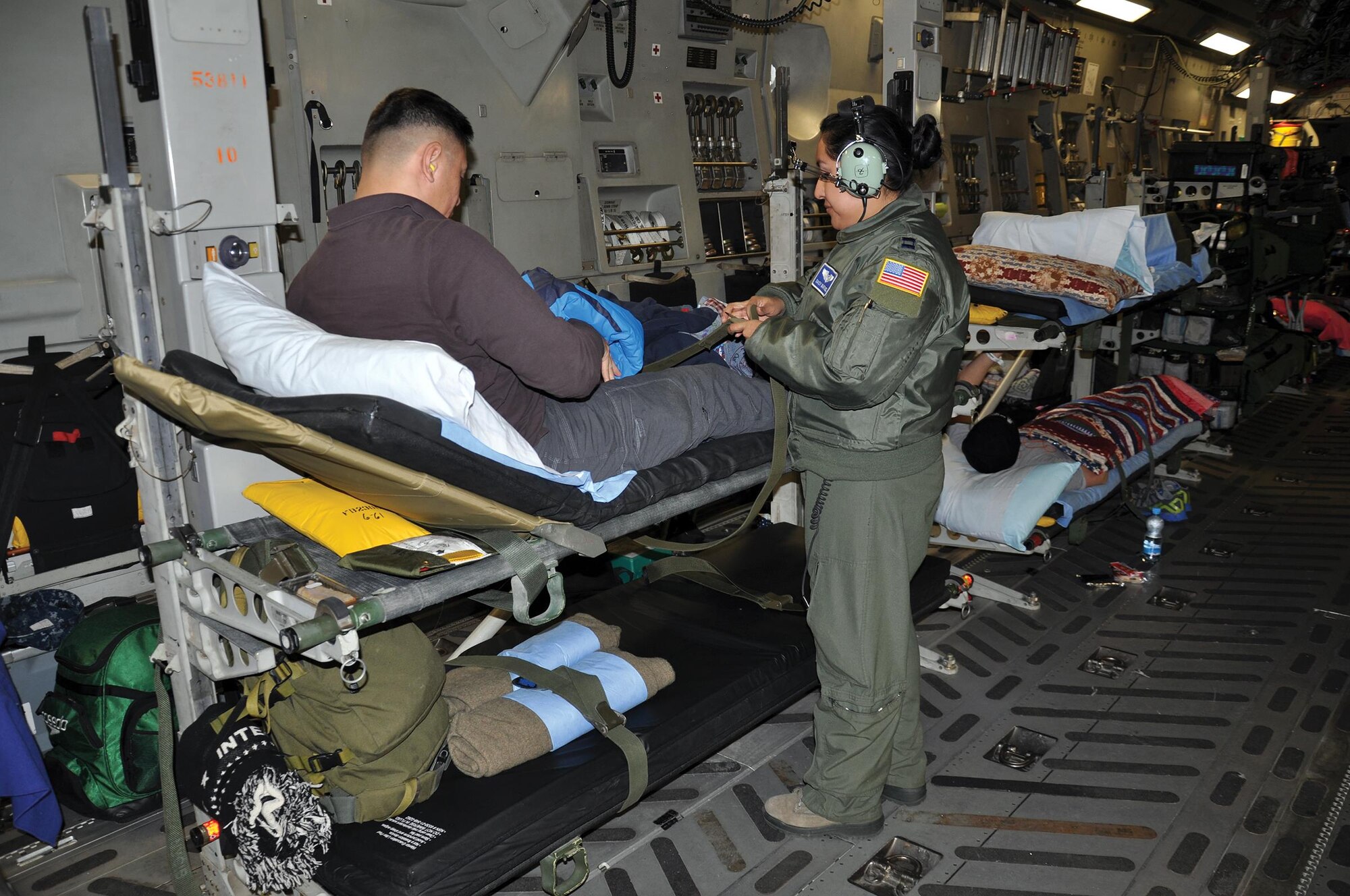 RAMSTEIN AIR BASE, Germany – Capt. Daisy Martinez, 86th Aeromedical Evacuation Squadron nurse, assists Maj. Stephen Ang, United States Army, during his Jan. 4, 2015 flight from Ramstein Air Base, Germany, to Joint Base Andrews, Maryland. Martinez stated that, of all the aircraft they use for aeromedical evac missions, the “C-17 is the most comfortable.” (U.S. Air Force photo/Capt. Elizabeth Caraway)