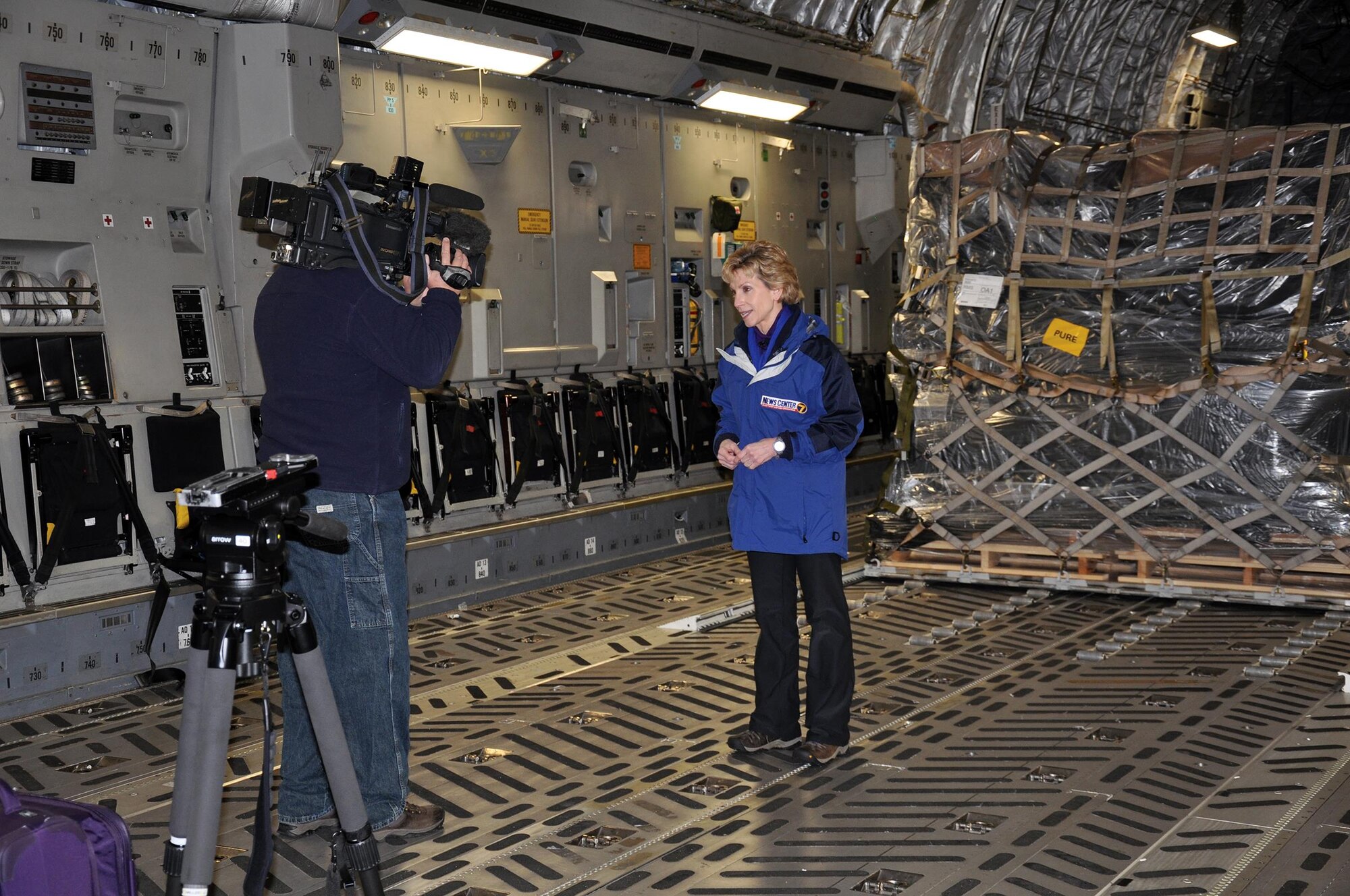 WRIGHT-PATTERSON AIR FORCE BASE, Ohio – Bob Garlock, Cox Media Group videographer, films WHIO-TV Dayton, Ohio news anchor Cheryl McHenry aboard a 445th Airlift Wing C-17 Globemaster III Dec. 31, 2014. McHenry and Garlock traveled to Afghanistan from Wright-Patterson Air Force Base, Ohio via Joint Base Andrews, Maryland and Ramstein Air Base, Germany Dec. 31-Jan 4, 2015. (U.S. Air Force photo/Capt. Elizabeth Caraway)