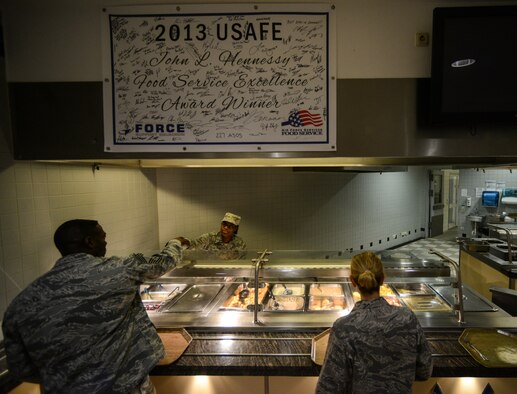 Airman 1st Class Raquel Hightower, 786th Force Support Squadron food service journeyman, serves breakfast at the Rheinland Inn Dining Facility, Ramstein Air Base, Germany, Feb. 4, 2015. Airmen at the DFAC ensure customers are aware of what they are putting into their bodies by categorizing options with green, yellow and red nutritional cards. (U.S. Air Force photo/Senior Airman Nicole Sikorski)