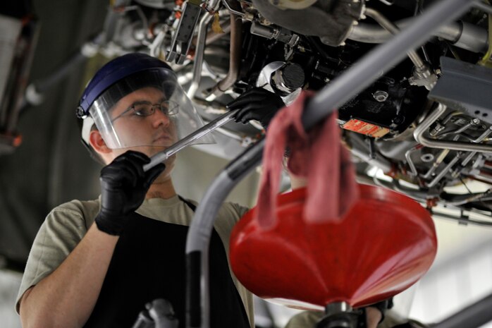 Senior Airman Thomas Rogers, a motor maintenance technician with the 437th Maintenance Squadron, changes the oil during a hard point inspection during night shift at Joint Base Charleston, S.C., Feb. 9, 2015. This home station check inspection helps ensure the safe functioning of the aircraft’s engines.. (U.S. Air Force photo/Tech. Sgt. Renae Pittman)