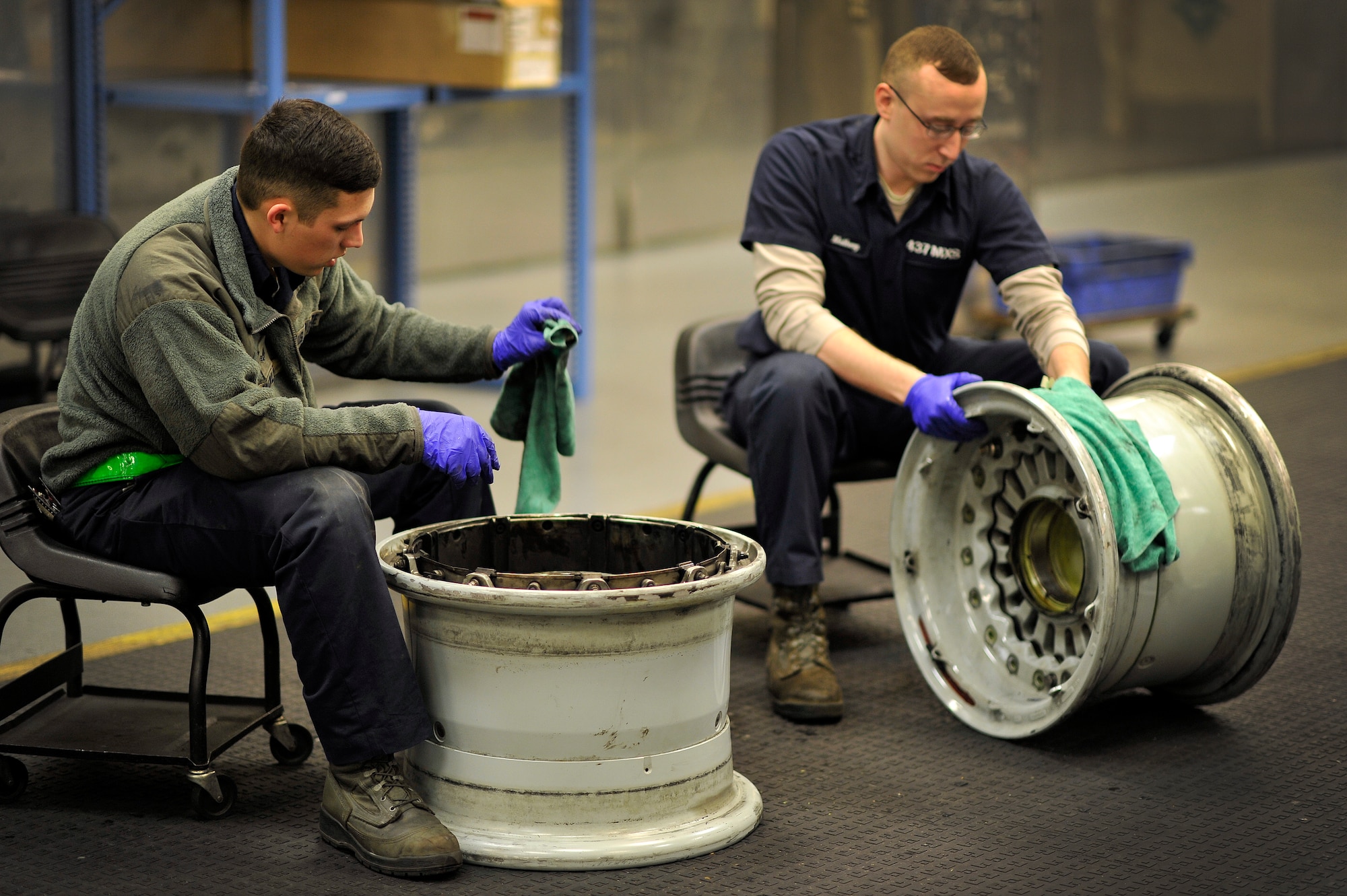 Senior Airman Terron Charles (left) and Senior Airman Bradley Matheny, crew chiefs with the 437th Maintenance Squadron, work in the aircraft recovery section cleaning tire rims at Joint Base Charleston, S.C., Feb. 9, 2015. While in the repair and reclamation section, these crew chiefs are expected to perform crash recovery, aero repairs, and wheel and tire maintenance. Their job continues both day and night. (U.S. Air Force photo/Tech. Sgt. Renae Pittman)