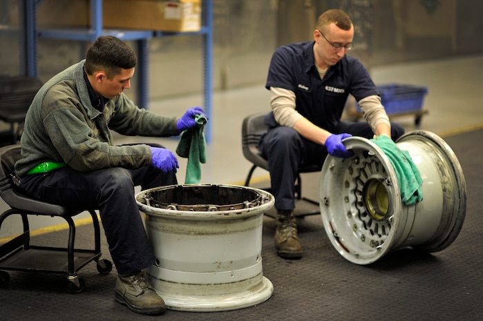 Senior Airman Terron Charles (left) and Senior Airman Bradley Matheny, crew chiefs with the 437th Maintenance Squadron, work in the aircraft recovery section cleaning tire rims at Joint Base Charleston, S.C., Feb. 9, 2015. While in the repair and reclamation section, these crew chiefs are expected to perform crash recovery, aero repairs, and wheel and tire maintenance. Their job continues both day and night. (U.S. Air Force photo/Tech. Sgt. Renae Pittman)