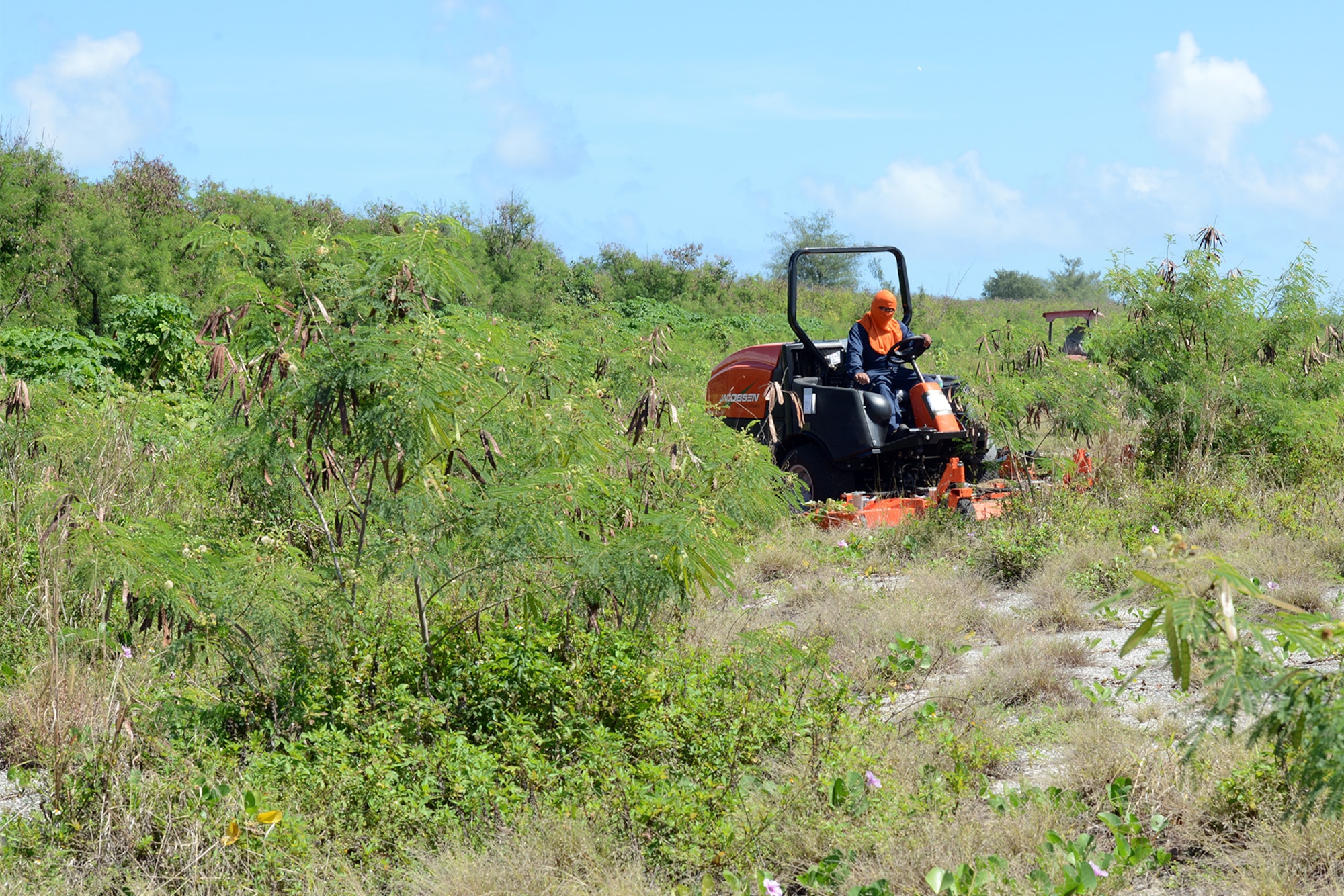 Manny Quenga, 36th Civil Engineer Squadron heavy equipment operator, mows the Baker landing zone at Tinian, Marianas Islands, Jan. 29, 2015. A crew of Dirt Boys from the 36 CES and local contractors at Tinian cleared the landing zone for Cope North 2015. (U.S. Air Force photo by Senior Airman Desiree Economides/Released)