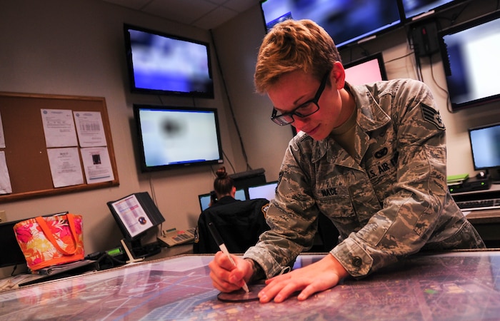 Staff Sgt. Jessica Nace, 628th Security Forces Squadron Base Defense Operations Center controller, simulates how an area is to be cordoned off if there were any potential threats Feb. 8, 2015, at the Air Base BDOC in Joint Base Charleston, S.C. The AB BDOC serves as the focal point for AB security and defense. It plans, directs, integrates, coordinates, and controls all AB defense efforts. (U.S. Air Force photo/Airman 1st Class Clayton Cupit)