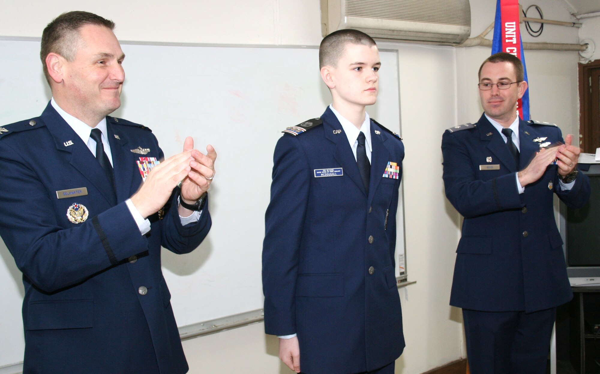 Col. Douglas DeLaMater (left), 374th Airlift Wing commander, presents newly promoted Cadet Capt. Michael McDougall, NHQ-103 Cadet Squadron commander, to the Yokota Cadet Squadron at Yokota Air Base, Japan, Feb. 6, 2015. Roughly five percent of those who enter the CAP cadet program reach the rank of Cadet Captain. (Civil Air Patrol photo by 2Lt Billie Thompson/Released)