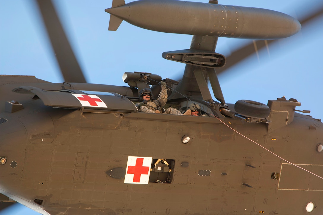 A U.S. soldier controls the hoist of a UH-60 Black Hawk medevac helicopter during a casualty evacuation exercise near Camp Buehring, Kuwait, Feb. 5, 2015.