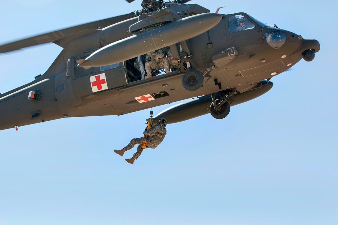 A U.S. soldier is lowered from a UH-60 Black Hawk medevac helicopter to the ground during a casualty evacuation exercise near Camp Buehring, Kuwait, Feb. 5, 2015.
