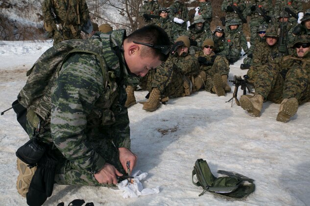 Republic of Korea Marine Gunnery Sgt. Kim Dong Jin, a Daegu, ROK, native, demonstrates ways to start a fire to U.S. Marines during Korean Marine Exchange Program 15-4 Feb. 4 at the Pyeongchang Winter Training Facility, Pyeongchang, Republic of Korea. The ROK and U.S. Marines learned different ways to survive in the cold mountainous terrain and also new ways of concealing themselves. KMEP is a regularly scheduled, bilateral, small-unit training exercise that enhances the combat readiness and interoperability of ROK and U.S. Marine Corps forces. Kim is a winter mountain warfare instructor with 1st Reconnaissance Battalion, 1st ROK Marine Division. The U.S. Marines are with Company L, 3rd Battalion, 3rd Marine Regiment, currently assigned to 4th Marine Regiment, 3rd Marine Division, III Marine Expeditionary Force under the unit deployment program. 